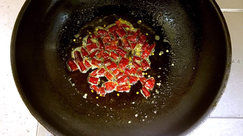 川味毛血旺,锅中放入约15ml的食用油，油5成热时放入剪好的干辣椒段炒出辣味。