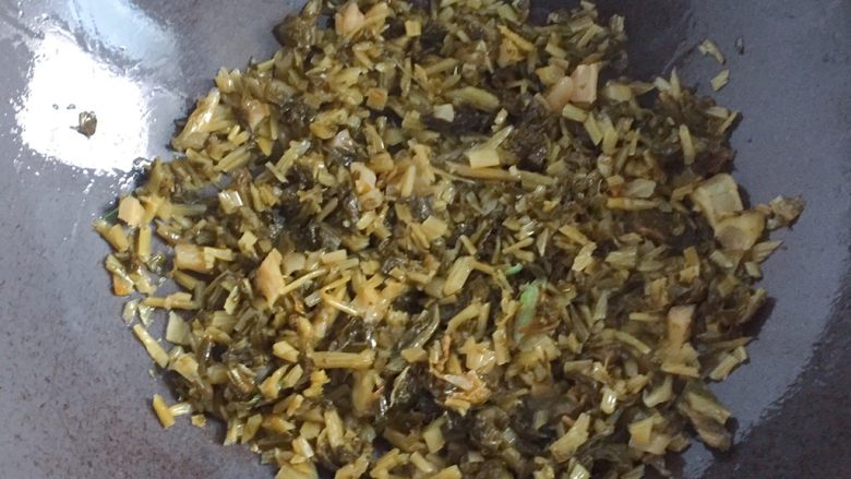 咸菜炒冬笋,另起锅倒入适量油，放入剩余的一半葱白炒香，放入咸菜煸炒。