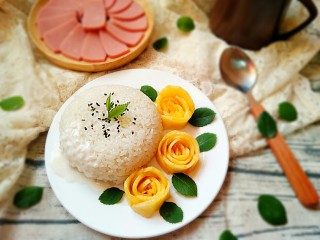 泰式芒果糯米饭,在糯米饭上撒一点黑芝麻，淋上剩余的椰浆和椰汁，用玫瑰叶装饰即可。