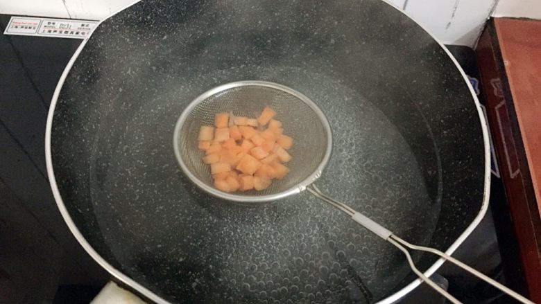 饺子皮披萨,锅中烧开水放入胡萝卜粒焯熟后沥干水分备用