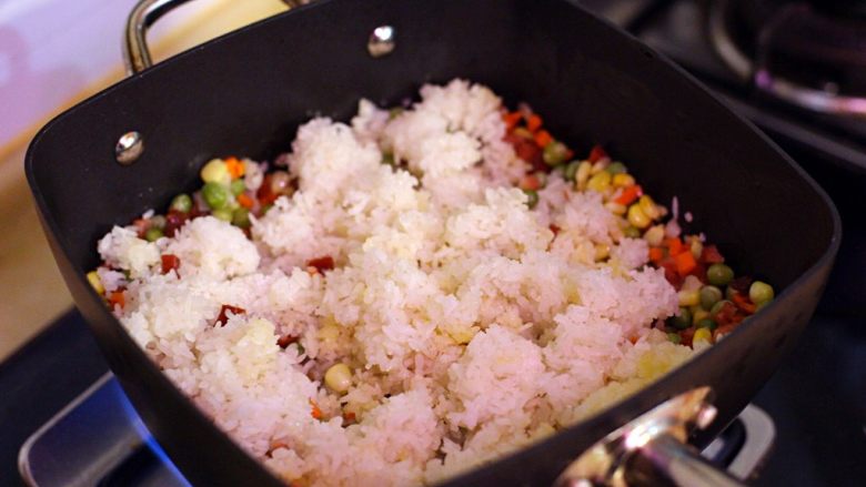 五彩斑斓菠萝饭,煮至水份快收干时倒入米饭加适量盐与糖翻炒均匀