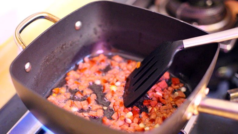 五彩斑斓菠萝饭,热锅后倒入色拉油，先倒入腊肠丁扁炒出香味。