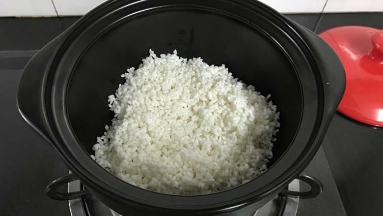 砂锅腊肠煲仔饭,倒入提前浸泡好的大米。