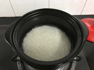 砂锅腊肠煲仔饭,加入过米半指甲的清水。然后再加入一勺油，搅匀。