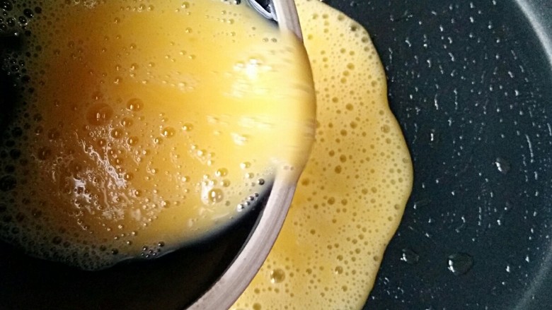 波点蛋包饭,平底锅刷一层薄油、开小火预热，有蛋黄的蛋液倒入平底锅煎成蛋饼、蛋饼表面凝固即关火。