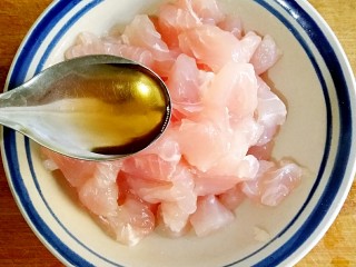 鱼米之乡,在鱼肉丁中调入1勺料酒、适量盐。