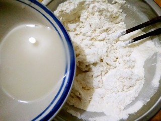 做饼+芝麻糖奶香菊花饼――这样的能量早餐敲好吃,将冲开的酵母水少量多次的加进面粉中，并用筷子搅拌成雪花状。