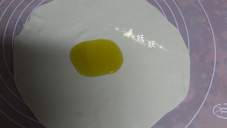 葱油烙饼,取其中的一个小剂子，擀成薄薄的片状，形状不规则也没用关系，尽量擀薄就可以了。面皮中间滴上植物油。