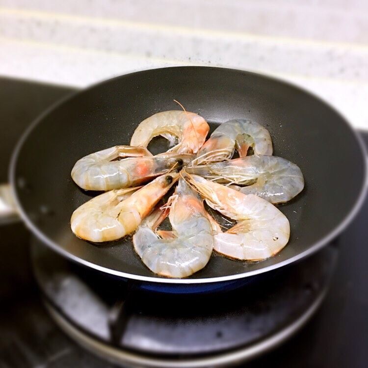 番茄大虾🍅,锅底淋入黑芝麻牛油果油、将虾摆放在锅中、两面翻炒至变色
