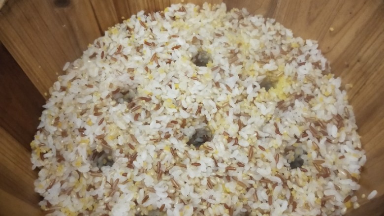 五谷杂粮木桶饭,蒸汽上来后，用筷子把米饭戳几个洞，以便蒸汽更好地上来，熟得更均匀。大约蒸制15-20分钟。