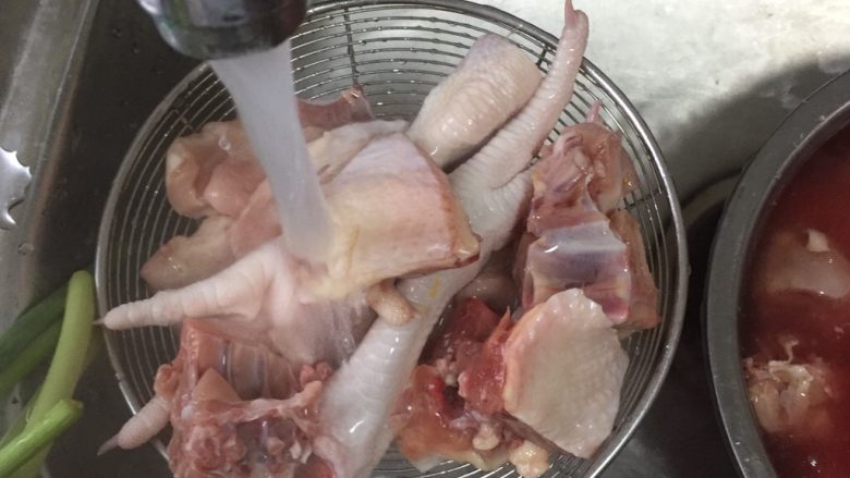 红烧鸡,用漏勺冲水，把鸡块沥干后，倒入锅内。