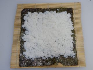 樱花寿司,在取一片海苔，铺在寿司帘上，均匀的铺上200g白米饭。