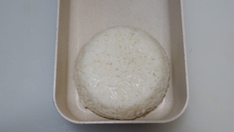 卡通狮子蛋烧便当「12」,扣入便当盒中。米饭边缘到饭盒边缘之间要有1CM的缝隙。