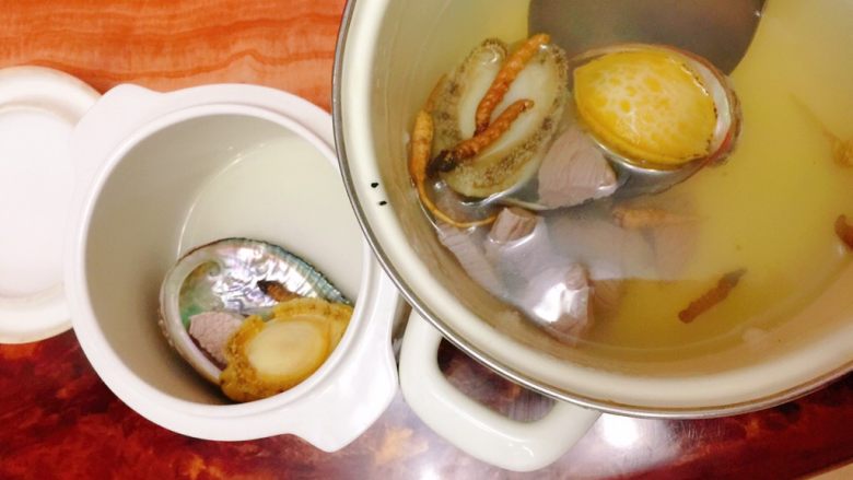 虫草鲍鱼炖汤,用勺子把所有食材连汤水一起倒入炖盅内。