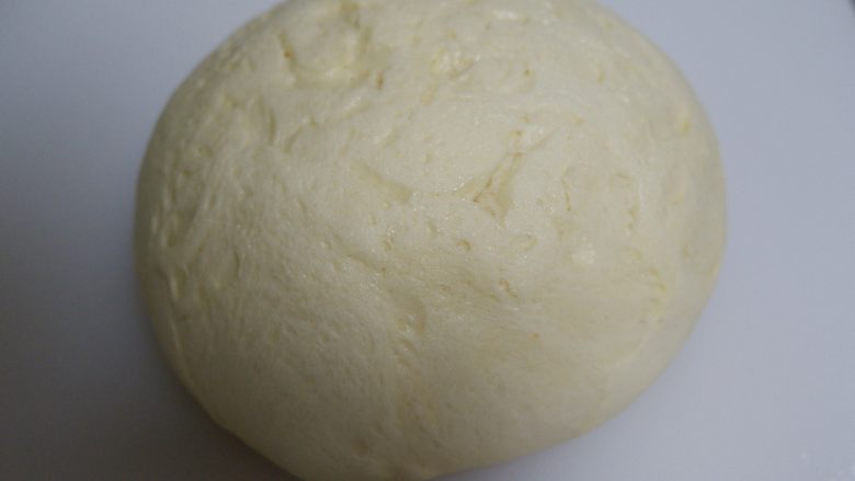 豆沙面包卷,发酵好的面团取出按压排气，边缘的大气泡拍掉。
