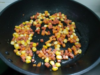 菠萝咖喱饭,倒入胡萝卜，玉米粒和火腿肠翻炒至快熟。