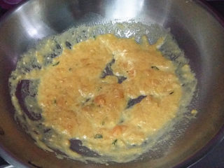 咸蛋黄焗锅巴,开中火边炒边转动锅铲，将咸蛋黄炒出油沙油沫