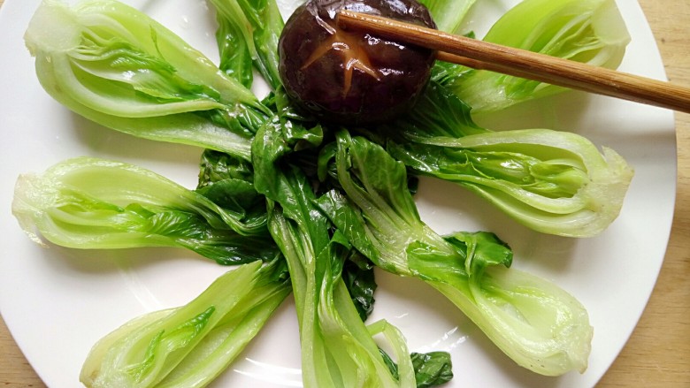 创意摆盘~蚝油香菇油菜,用筷子先将香菇夹到油菜上面摆盘，再淋上汤汁