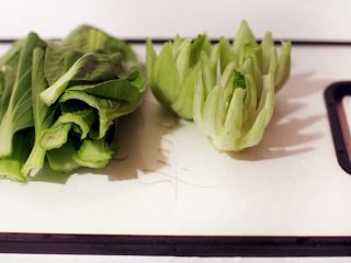 话梅鸡翅,小棠菜用水洗净，将小棠菜头在适当的位置切开，用剪刀将每片叶子修成尖角状。