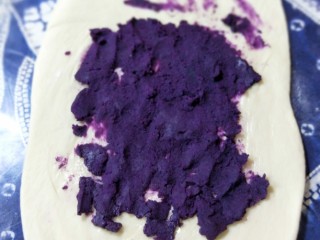 紫薯辫子面包,将一半的紫薯泥均匀地平摊在面皮上。