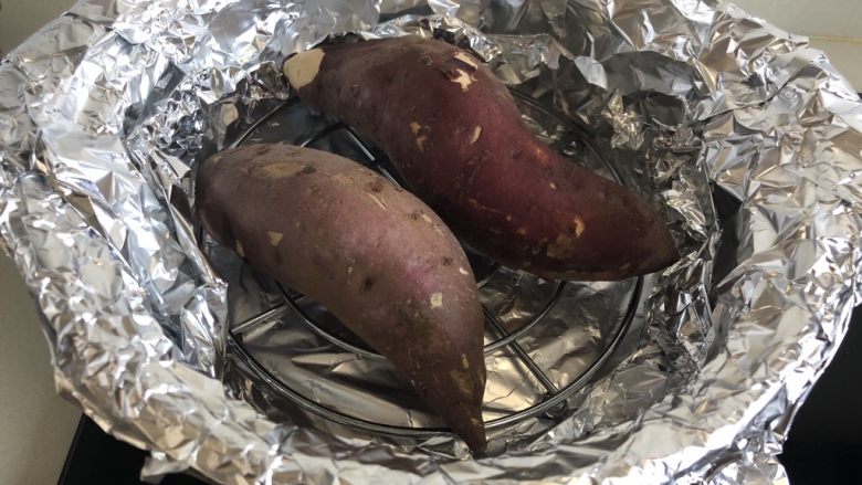 砂锅烤红薯,把两个红薯放在支架上。