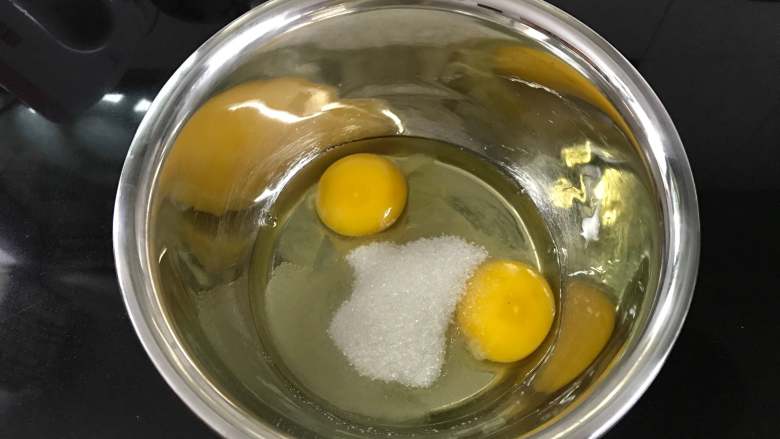 小红帽杯子蛋糕 ,把两个鸡蛋打入无水无油的盆中。加入白砂糖。