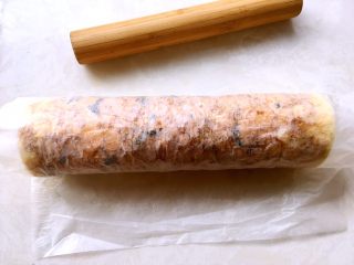 海苔肉松蛋糕卷,利用擀面杖向外卷起油纸，将蛋糕卷卷起来，卷好之后包裹油纸固定一下形状