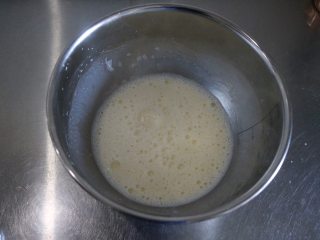 爆浆海盐奶盖蛋糕,慢慢倒入搅拌好的蛋黄糊中，一边倒牛奶一边搅拌；