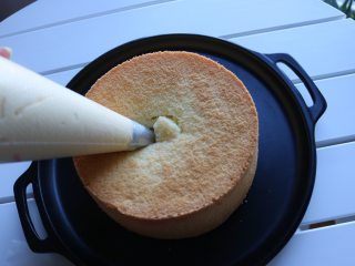 爆浆海盐奶盖蛋糕,准备一个圆形裱花嘴，装入裱花袋中，然后将海盐芝士装入裱花袋中，轻轻地将奶盖酱挤入蛋糕中间；
