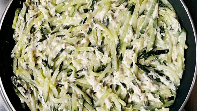 鲜虾青瓜烙,把拌好生粉的青瓜均匀平铺在不沾平底锅中。