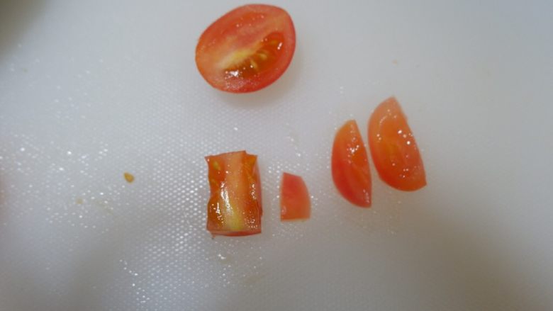 圣诞花环沙拉盘,取一个小番茄。切掉圆形的边角。取中间的长条状。