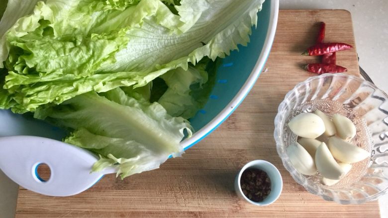 翡翠包包➕炝拌生菜卷,蒜剥皮，生菜撕成一片片放在洗菜盆里备用