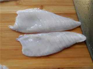 砂锅爆炒鱿鱼,把鱿鱼无皮的那面朝上，在鱿鱼身上轻轻的斜着切出间隔为3毫米宽的条，不要把鱿鱼切断。