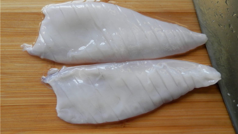 砂锅爆炒鱿鱼,把鱿鱼无皮的那面朝上，在鱿鱼身上轻轻的斜着切出间隔为3毫米宽的条，不要把鱿鱼切断。