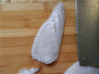 砂锅爆炒鱿鱼,全部切好后，将鱿鱼转个方向，用倾斜45度的刀，切间隔为3毫米宽的条，勿切断鱼身。