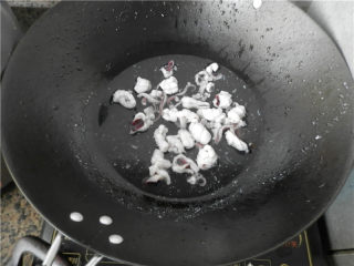 砂锅爆炒鱿鱼,锅中倒入清水，置电磁炉大火煮开后，淋入料酒，将切好的鱿鱼放入焯烫至打卷立即捞出。