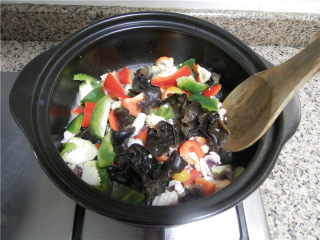 砂锅爆炒鱿鱼,放入黑木耳、红椒、青椒，不断翻炒至断生。