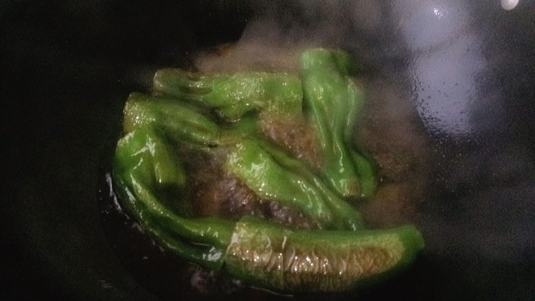青椒塞肉（家庭版）,加入热水。没过青椒。调制中火大约煮个5-6分钟。因为肉是生的需要多煮一会儿。期间要用锅铲轻轻推动几下。