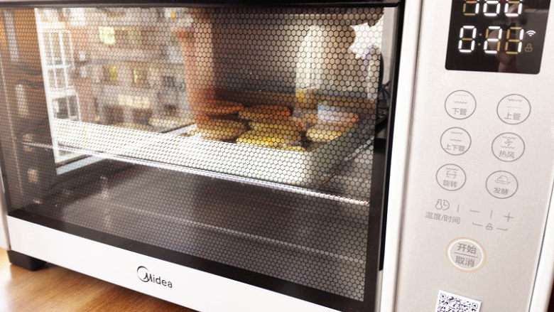 豆沙老婆饼,烤箱180度预热，这里烤箱的温度，要根据自己的烤箱温度来调节，美的智能大烤箱温度有些偏高，所以这里用了160度，中层，烤10分钟
