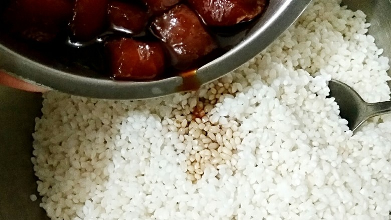 鲜肉粽子,将泡好的糯米沥水，把腌鲜肉的汤汁倒进糯米中，拌匀。