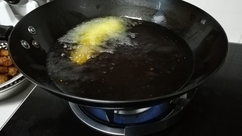 秘制油炸肉丸,用手抓一把肉泥，挤出一个小团，小勺子挖下放入油锅里