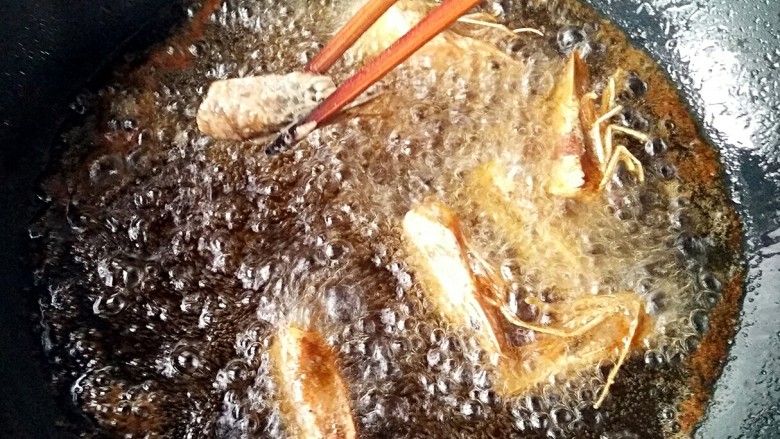 一虾两吃――《外科风云》同款：香酥虾壳&茄汁虾球,锅中适量油，烧至5成热，逐个放进虾头中小火炸2分钟。
