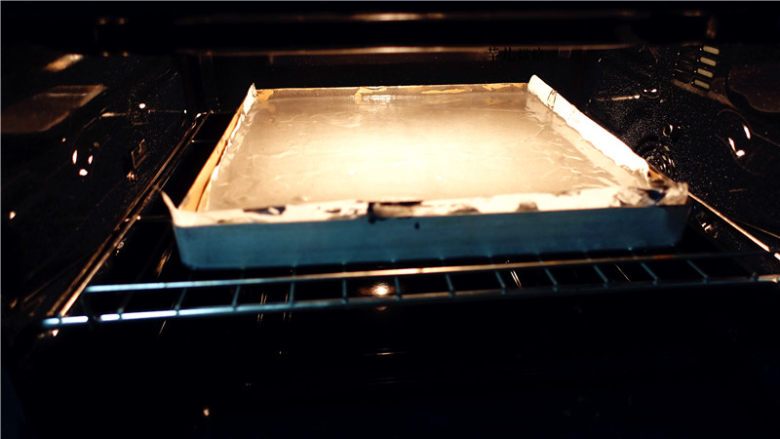 竹炭奶油卷,将蛋黄糊从高处从上往下慢慢倒下，倒入烤盘中，高处倒下的过程有助于震破表面的气泡。将烤盘放入150度预热好的烤箱，烤制15--20分钟。