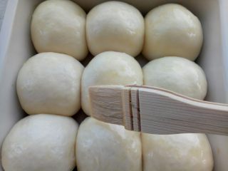 椰蓉小面包,用手指粘点面粉轻轻按一下发好的面团，如果慢慢回弹证明已经发好了，刷一层蛋液，烤箱180度预热。

