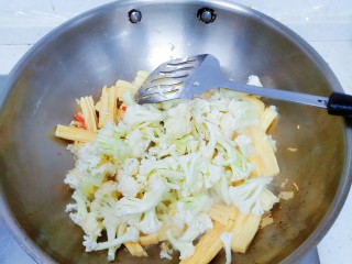 菜花腐竹焖肉片,倒入腐竹和菜花，一起翻炒。