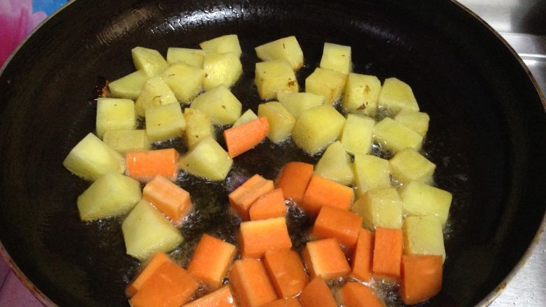 咖喱牛肉盖浇饭,
不粘锅加适量油烧至3成热，倒入土豆丁和胡萝卜丁