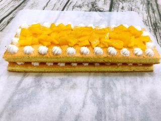 水果蛋糕,再铺上一层蛋糕片，挤上一圈奶油，中间铺上黄桃块
