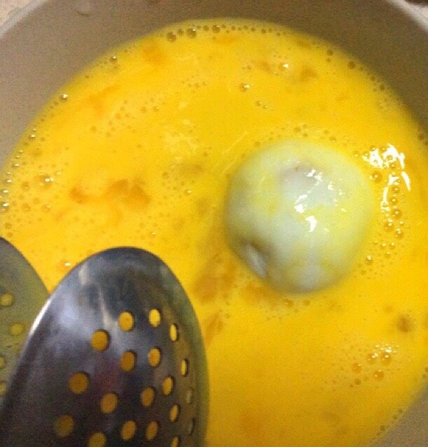 香蕉馅糯米土豆干炸丸子,取丸子在蛋液里裹一下