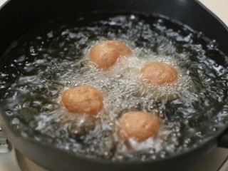 四喜丸子,锅中放适量食用油烧至八成热，将丸子一个一放入油锅中