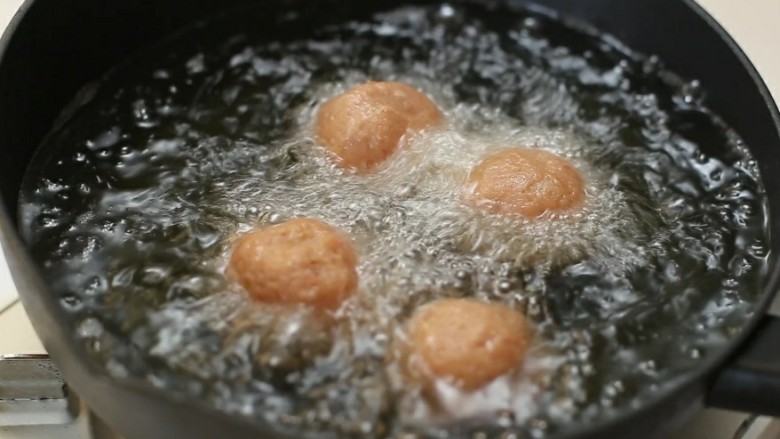 四喜丸子,锅中放适量食用油烧至八成热，将丸子一个一放入油锅中